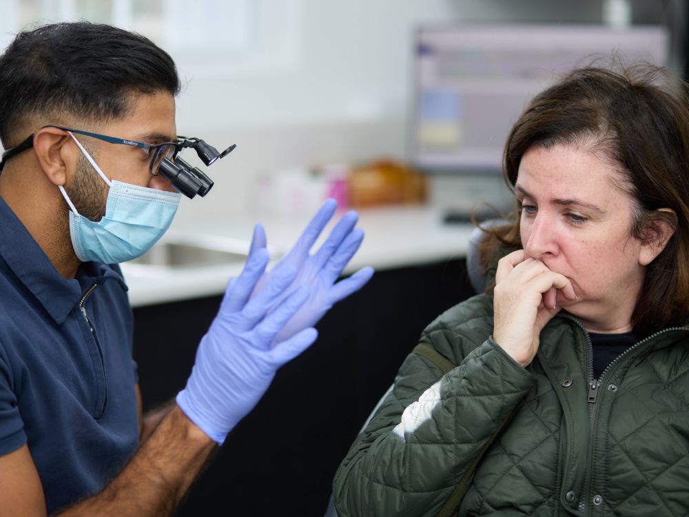 A dentist talking a patient through her treatment