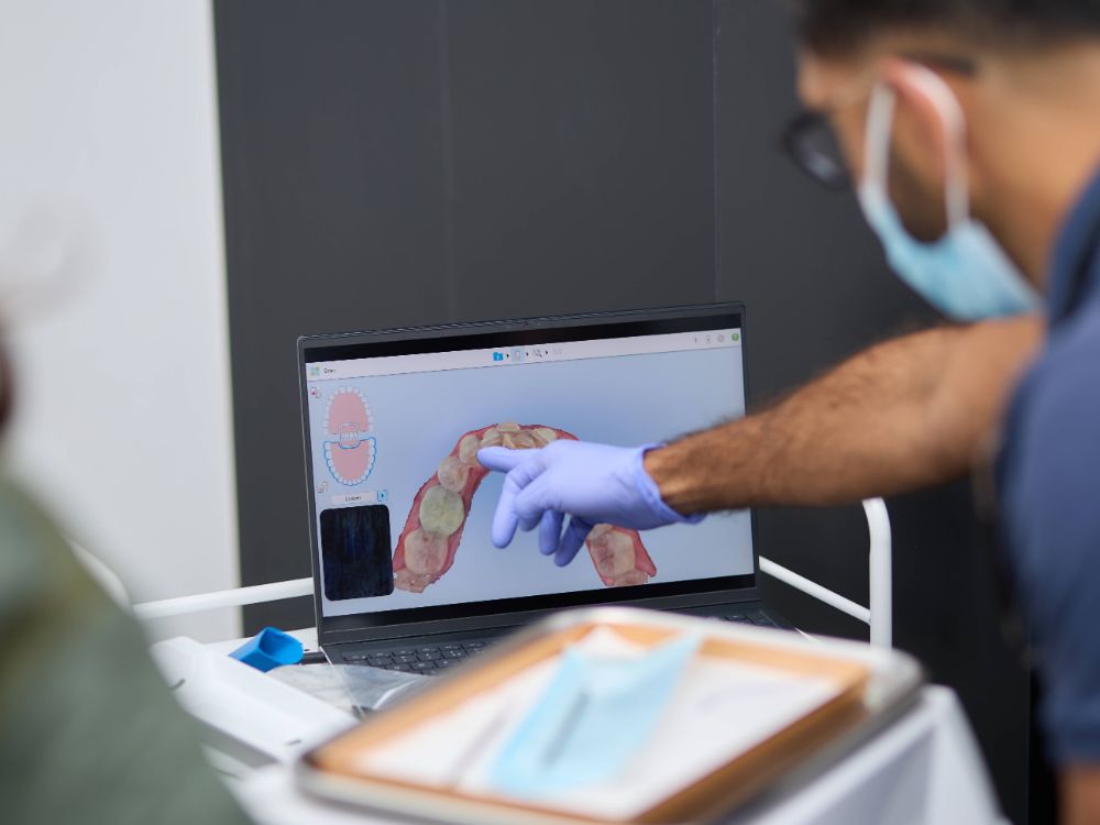 A dentist showing a patient images on a screen